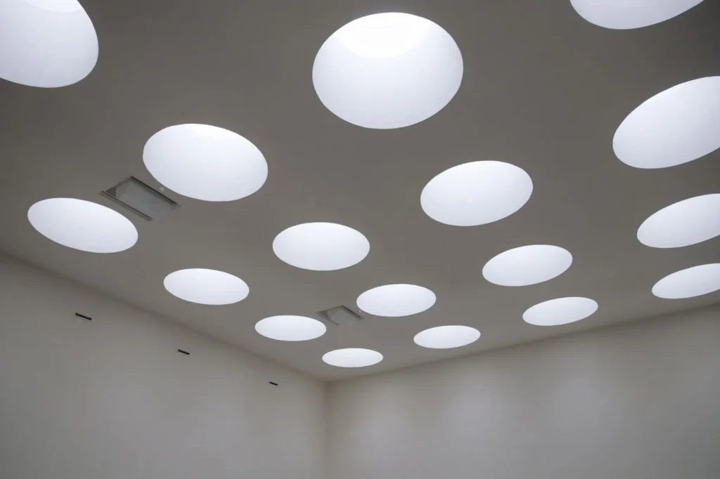 Trappe de visite ouverte dans un faux plafond en plaques de plâtre, donnant accès aux gaines techniques