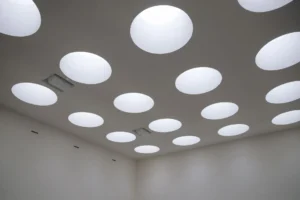 Trappe de visite ouverte dans un faux plafond en plaques de plâtre, donnant accès aux gaines techniques