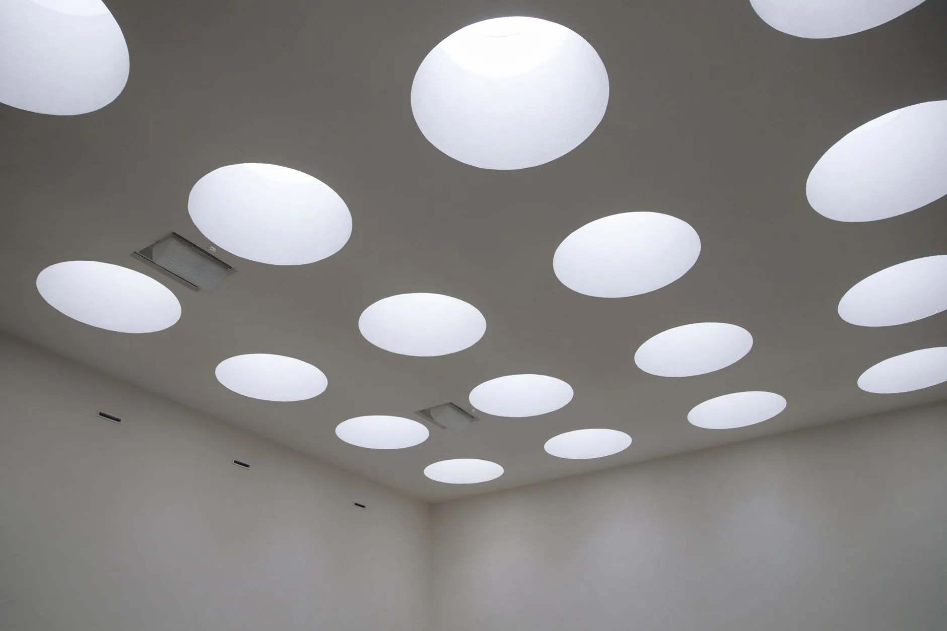 Trappe de visite ouverte dans un faux plafond en plaques de plâtre, donnant accès aux gaines techniques